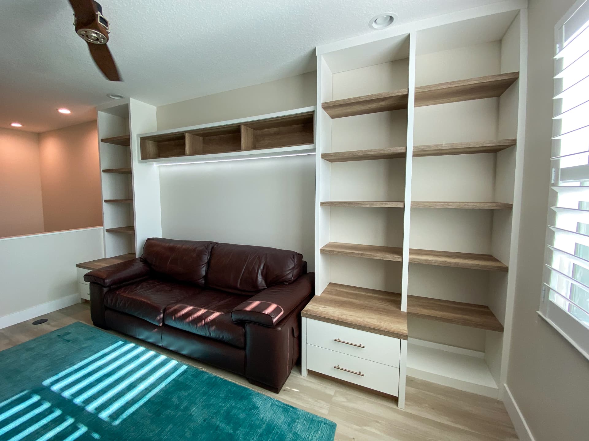 White built-in wall shelving with wood-tone shelves